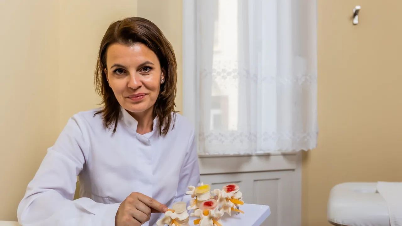 Szentiványi Rita gyógytornász-manuálterapeuta egy gerincmodell mellett ül