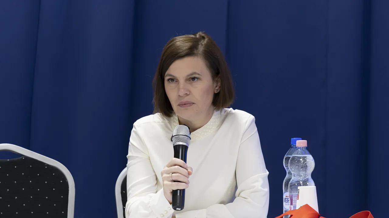 Előadó mikrofonnal a szakmai nap pódiumán